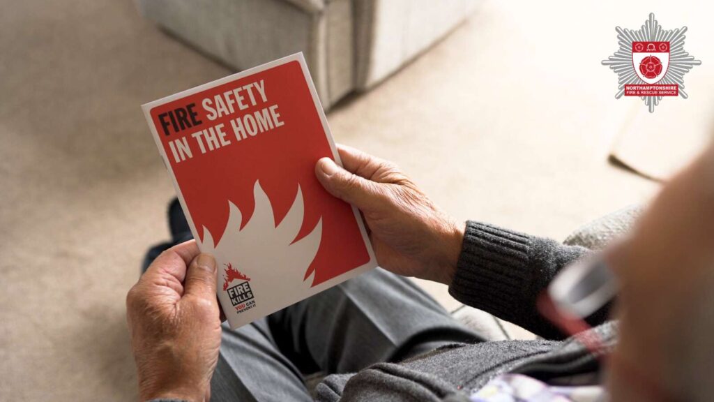 Stock image of an older persons pair of hands holding a Fire safety in the home leaflet.