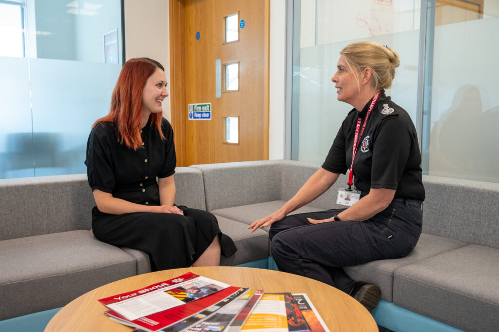 Jenna Marsh of the Home Office, pictured on the left, is shown sitting down in conversation with Chief Fire Officer Nikki Watson, pictured on the right.