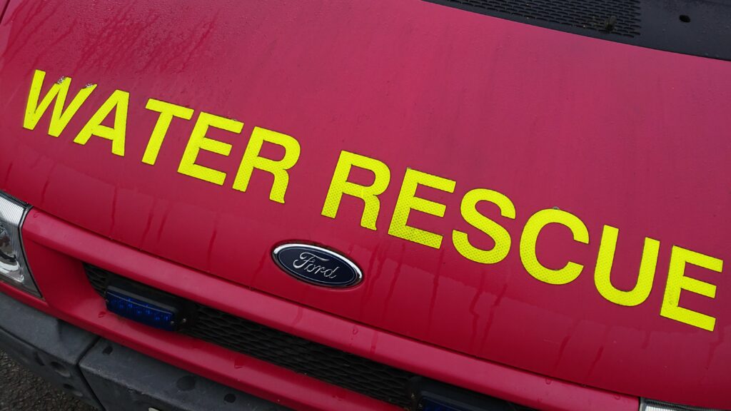 WATER RESCUE written in yellow on the bonnet of a red van