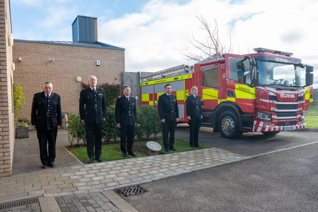 Five senior leaders from NFRS standing to attention next to a fire engine